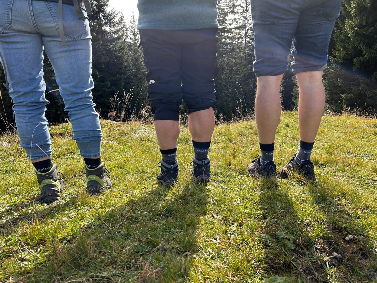 Drei Personen mit Bolter-Trekkingsocken auf einer Wiese